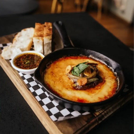 Provoleta de La Mattina gratinada en sartén de fierro, con pan y chimichurri